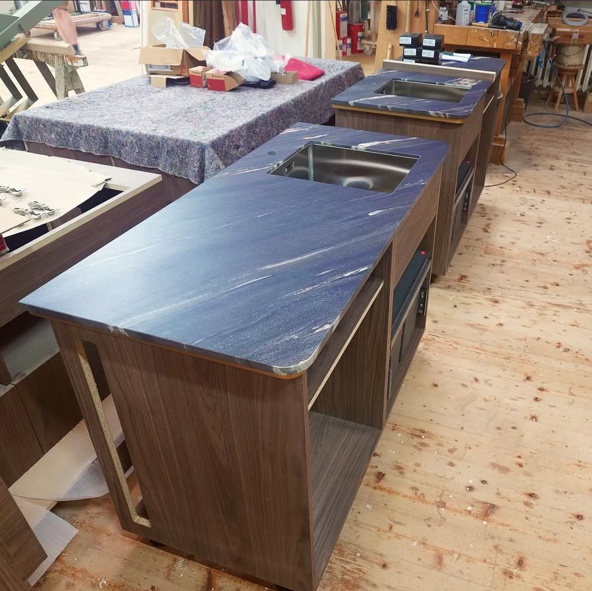 Zwei Werkbänke mit Natursteinplatten und Spülenausschnitten